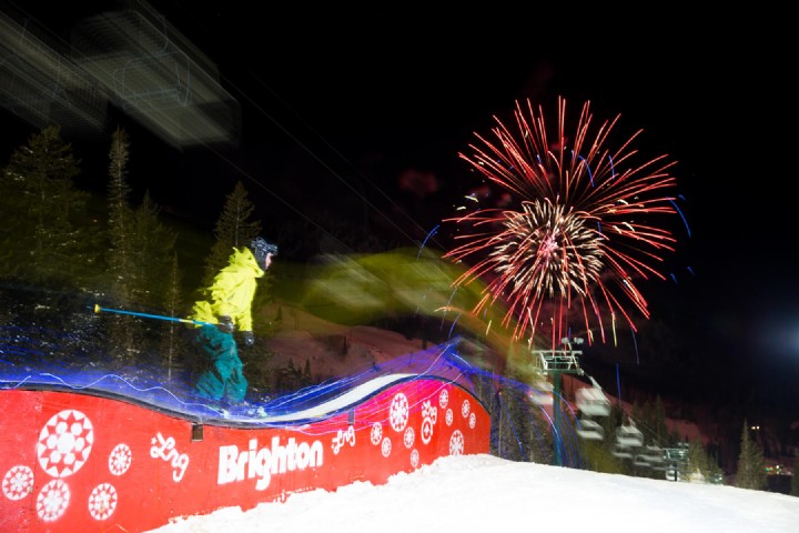 a skier goes over a rail at night