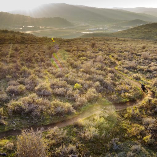 overhead view of a bike trail winding through rolling hills covered in sagebrush