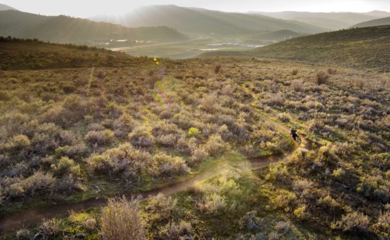 overhead view of a bike trail winding through rolling hills covered in sagebrush