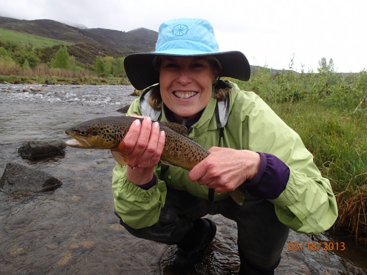 a woman holds a fish she caught