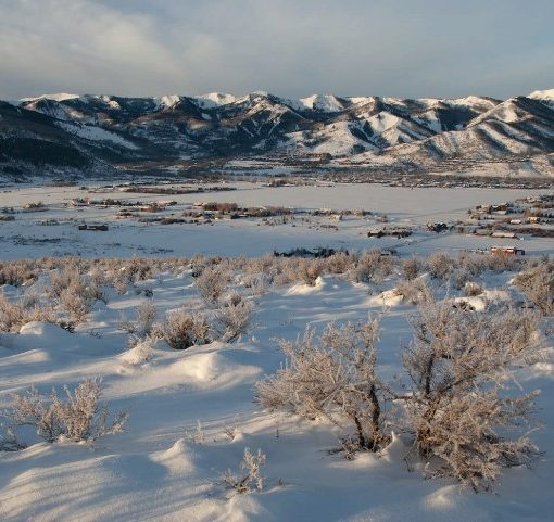 snowy field in the foreground, Wasatch back ski resorts in the distance
