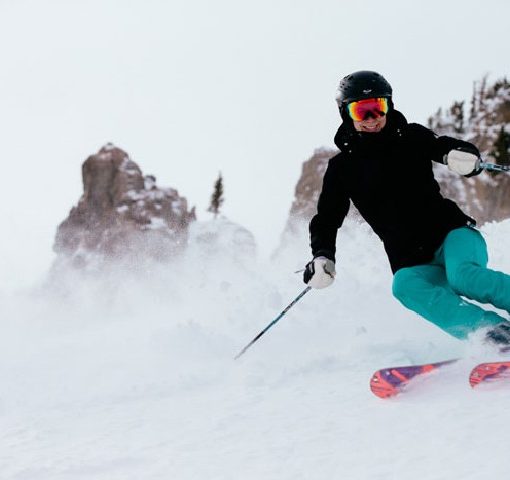 female skier carving a turn with a smile