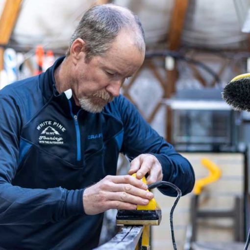 Ski technician preps Nordic ski for summer storage