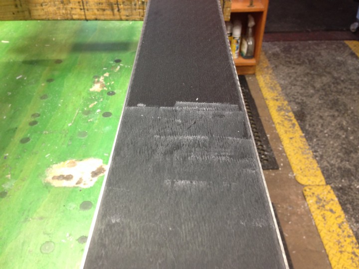 Rubbing wax on ski base before ironing