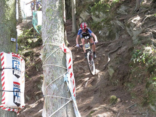 A mountain bike riders descends a technical trail