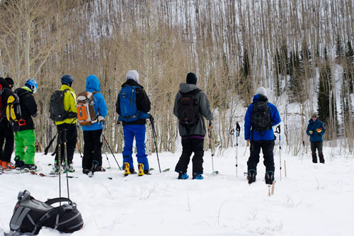 Skiers line up on a ridge during avalanche courses