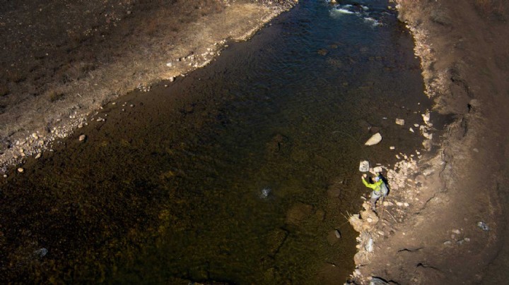 Fisherman casts into a river. Shot from above
