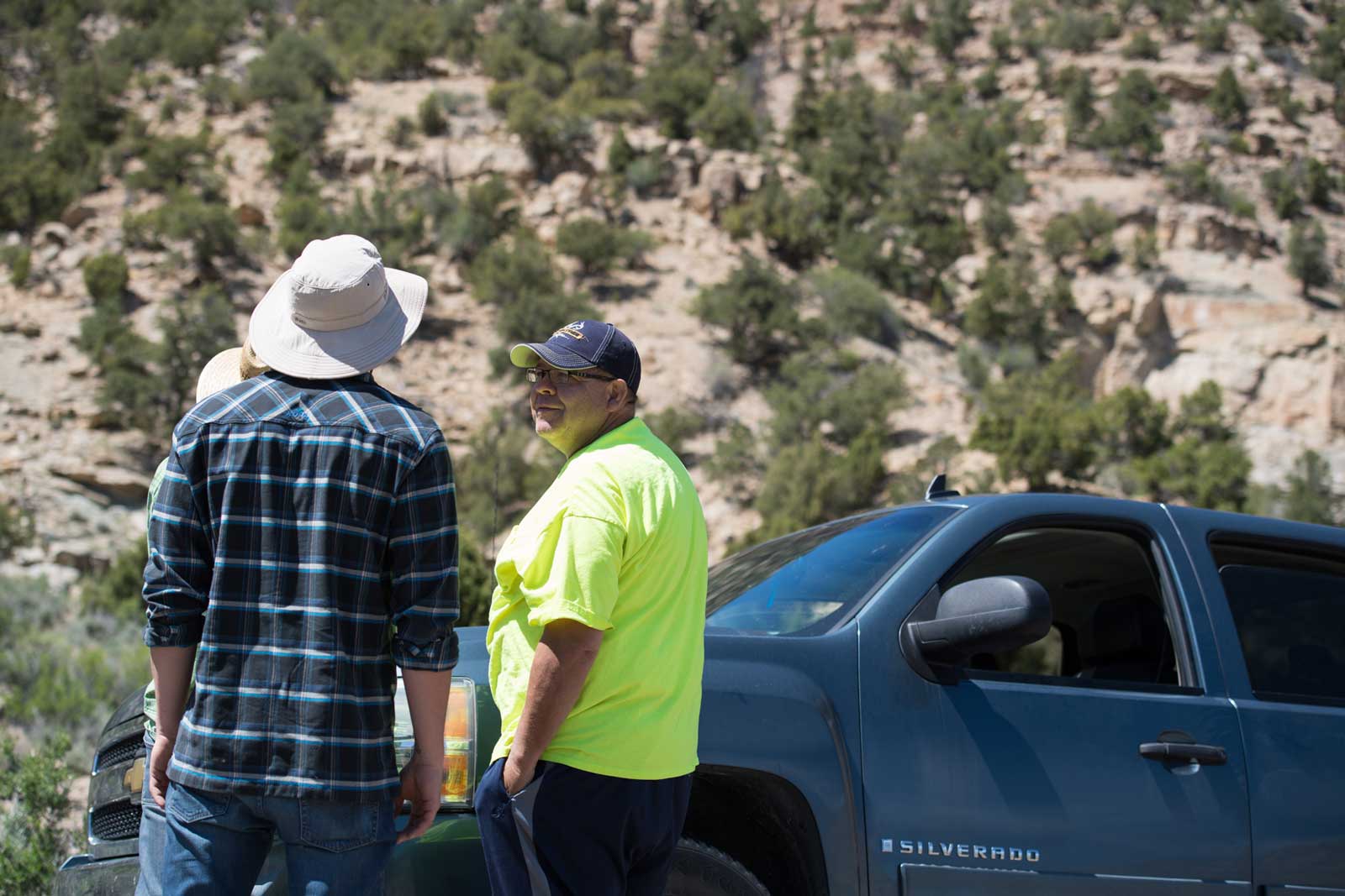 Three men discuss Native American art in the Utah desert
