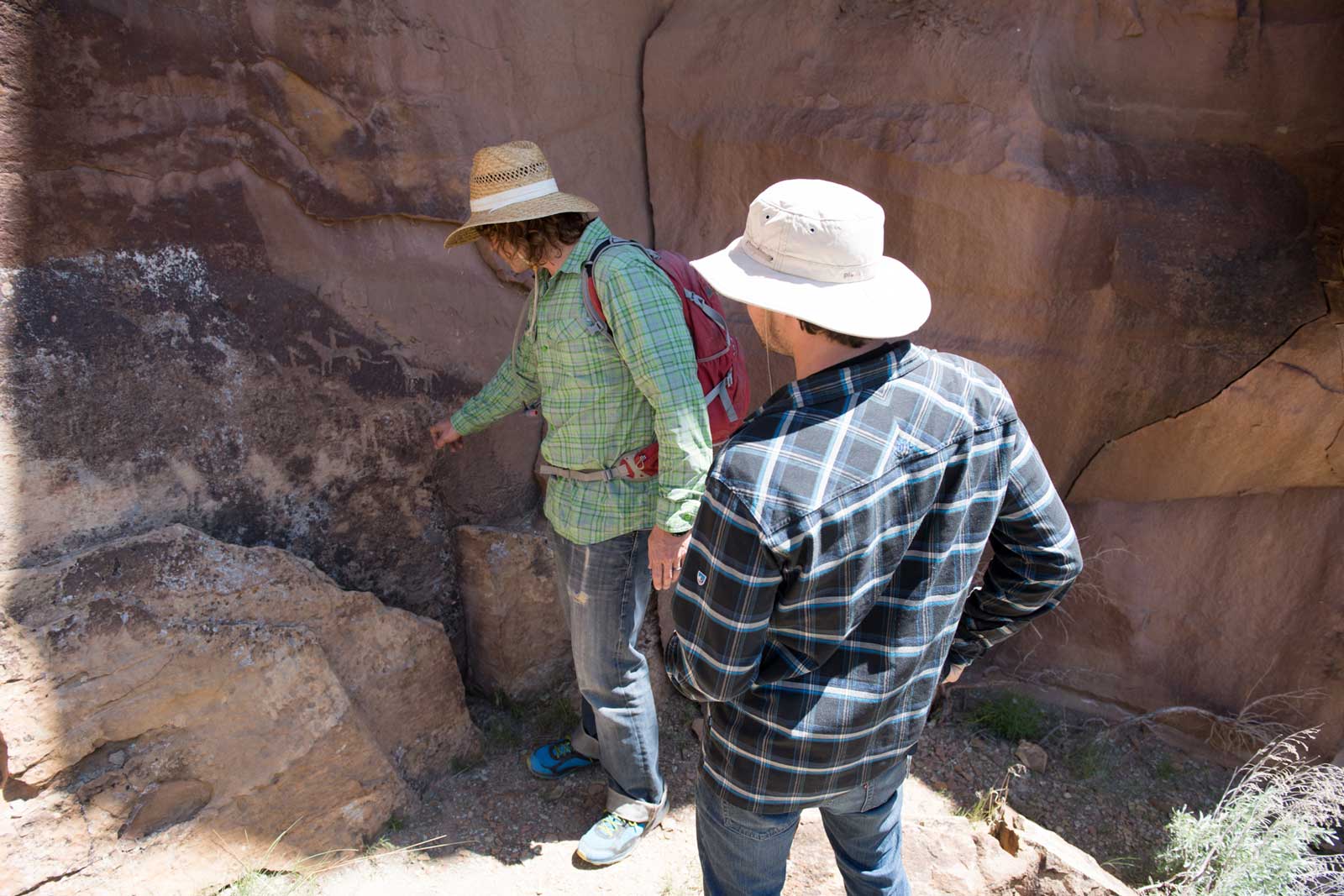 Two men view Native American petroglyphs in the Utah desert