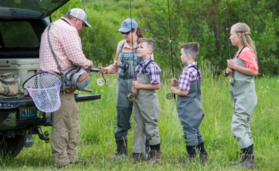 A guide helps young children get ready to fish