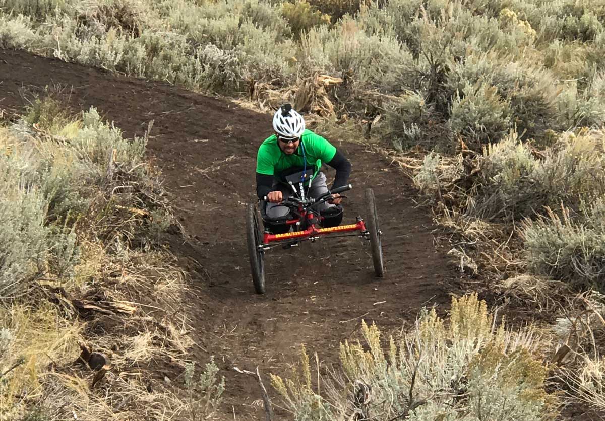 An adaptive mountain biker descending the Down Dog trail in Park City, UT