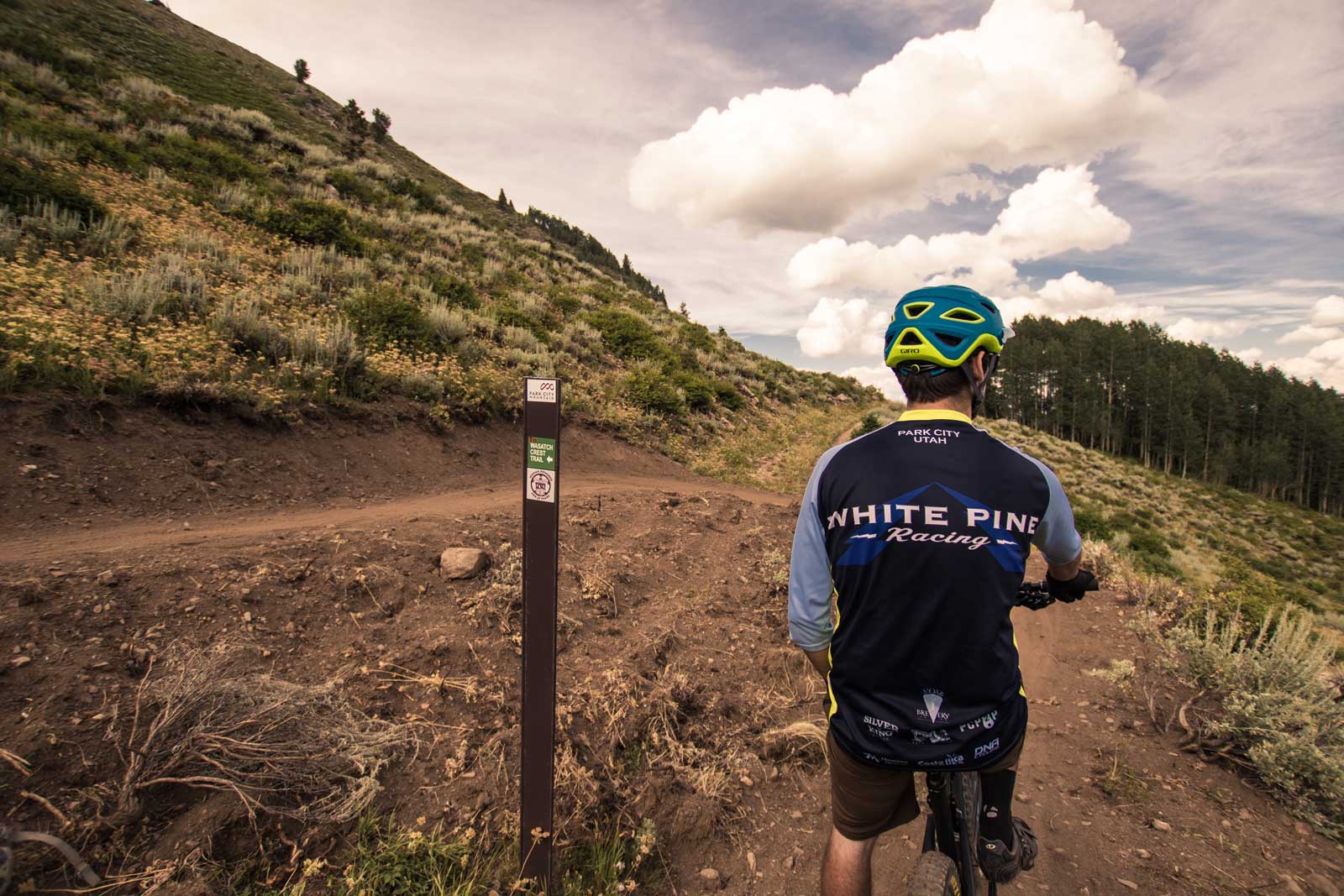 A mountain biker resting at the top of the Blazing Saddle trail in Park City, UT