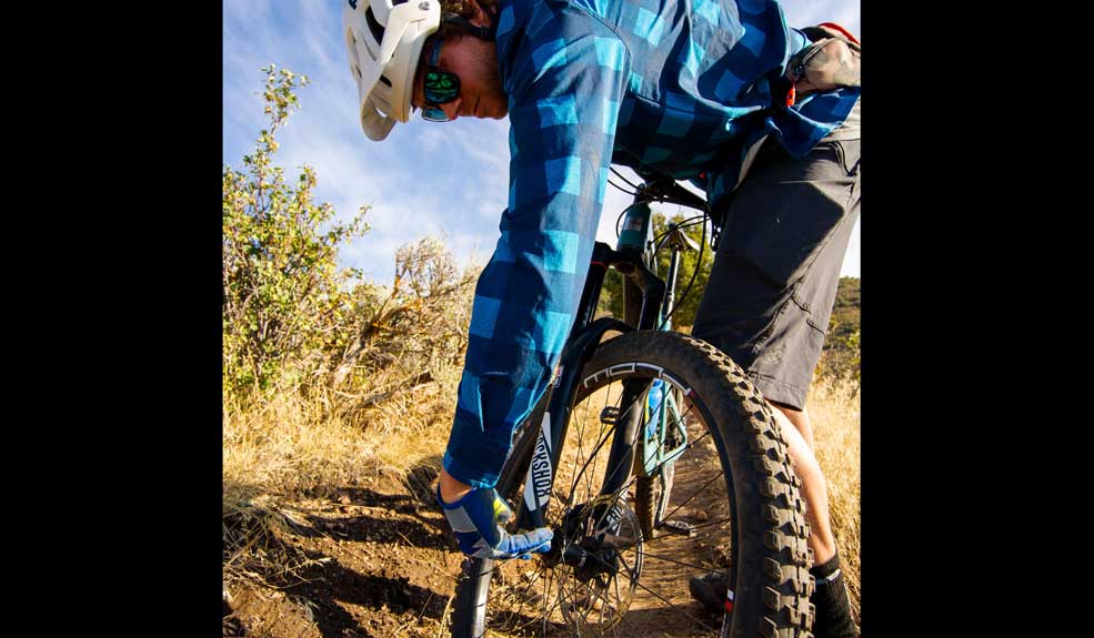 Mountain biker check his front wheel axle after a crash