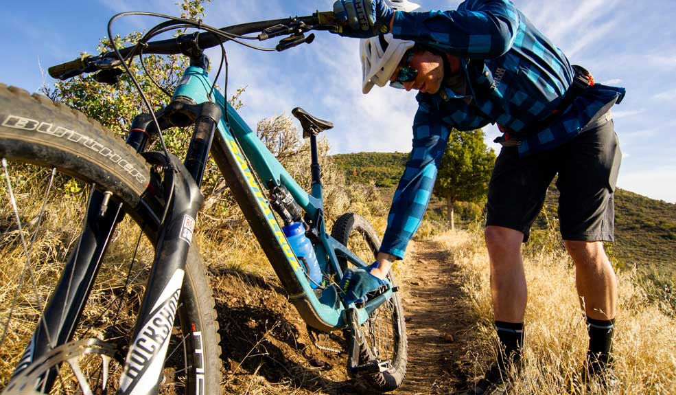 Mountain biker making a visual inspection of his bike after a crash
