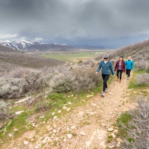 3 hikers hiking through stormy weather in Round Valley, Utah