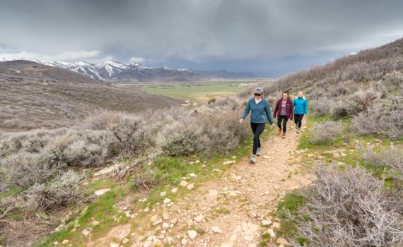 3 hikers hiking through stormy weather in Round Valley, Utah