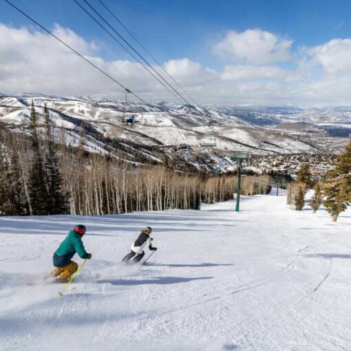 Two skiers ski under a lift at Deer Valley REsort