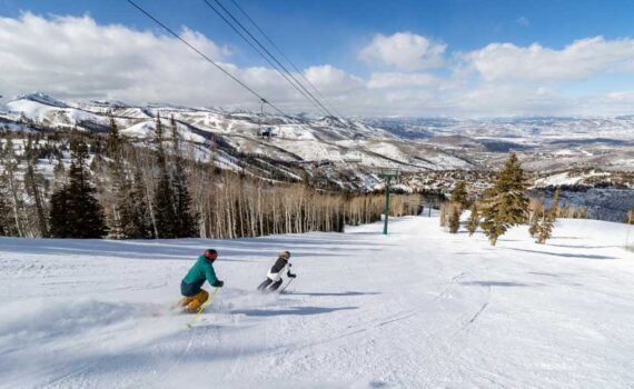 Two skiers ski under a lift at Deer Valley REsort