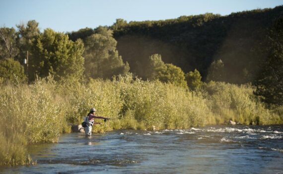 A Jans employee wades into the provo river while fly fishing.