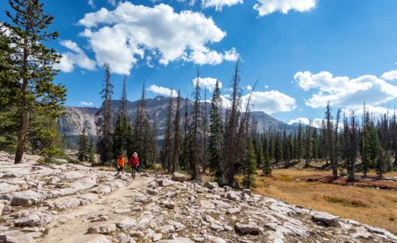 Two hikers head towards Ruth Lake in the Uinta Mountains.