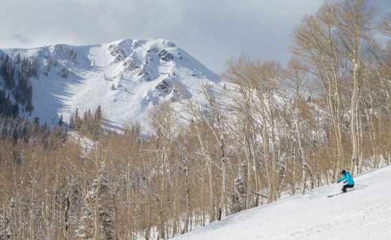 A skier carves a turn on a groomed run below Jupiter Peak in Park City, UT