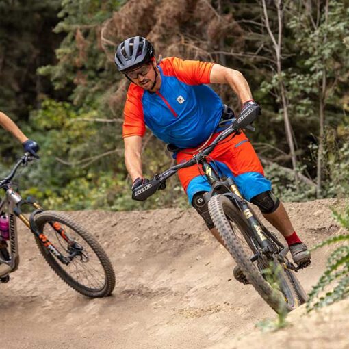 Jans experts race at Deer Valley, one is wearing a red and blue bike kit, the other is wearing a full faced helmet.