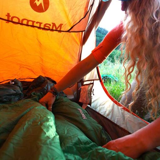 Jans Expert lays out a sleeping bag in her tent while out in the backcountry.