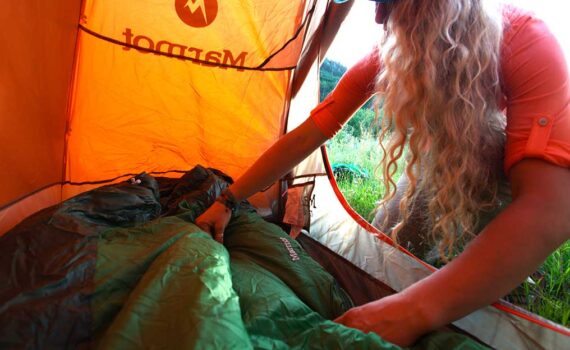 Jans Expert lays out a sleeping bag in her tent while out in the backcountry.