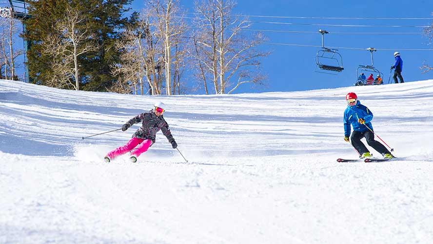 Jans expert skiers carving on a groomed run on High Performance skis at Deer Valley Resort, Park City, UT