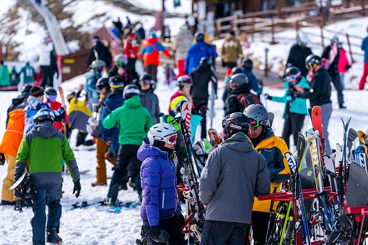 Crowds at the base of Park City Mountain Resort with racks of rental skis