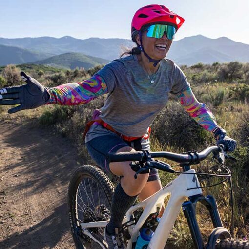 Jan's Expert smiles and reaches for a high five while riding at Round Valley