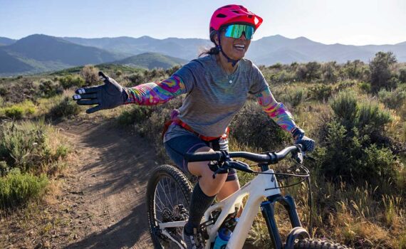 Jan's Expert smiles and reaches for a high five while riding at Round Valley