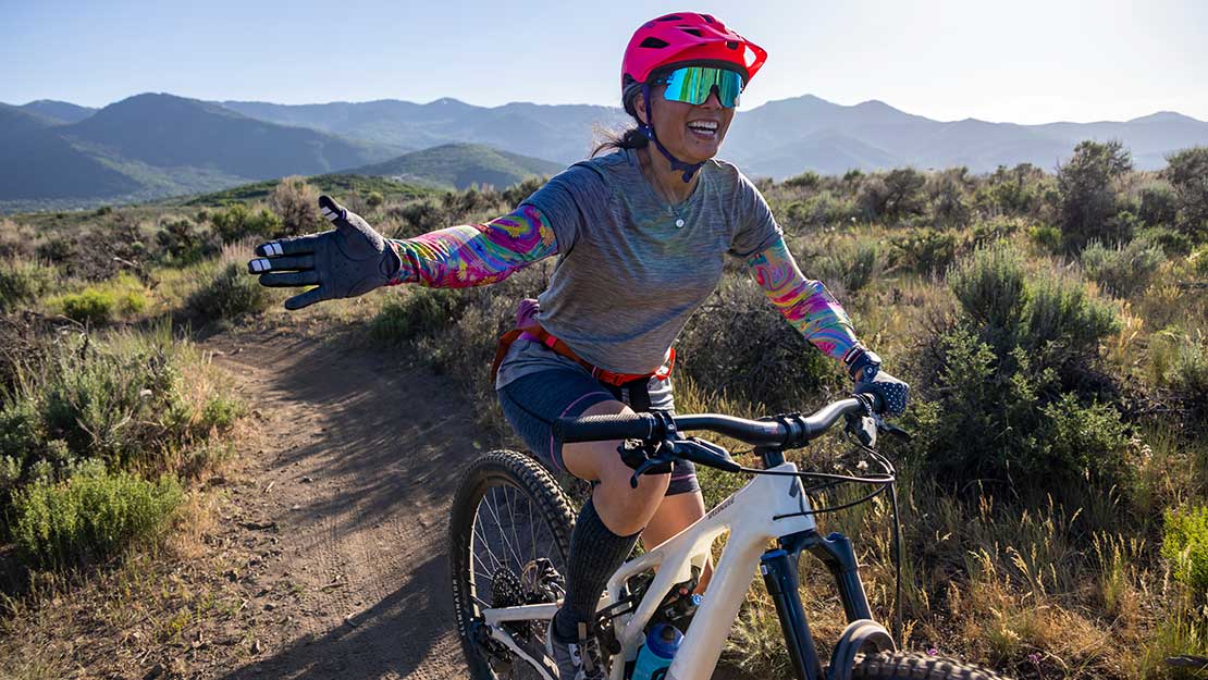 Jan's Expert smiles and reaches for a high five while riding at Round Valley