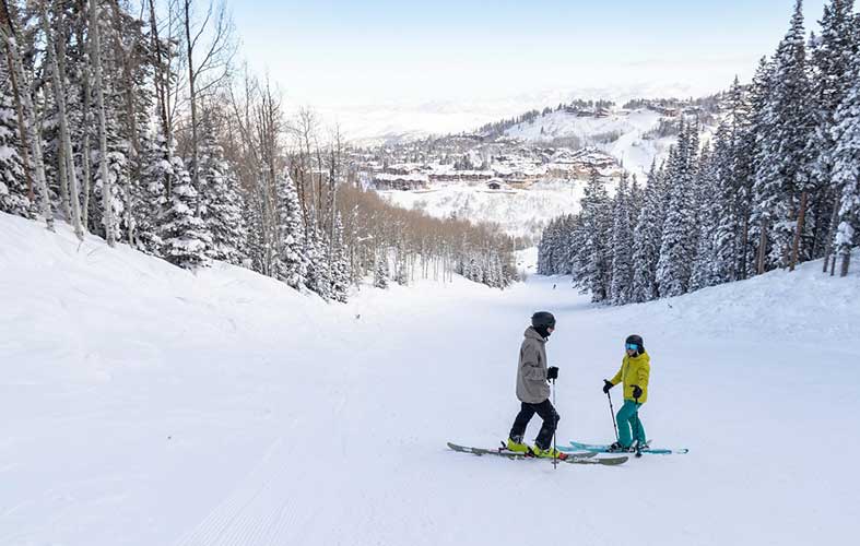 Skiers stop in the middle of an empty ski run at Deer Valley Resort 